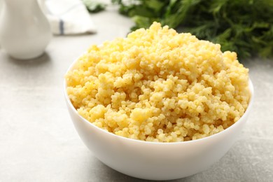 Photo of Tasty millet porridge on grey textured table, closeup