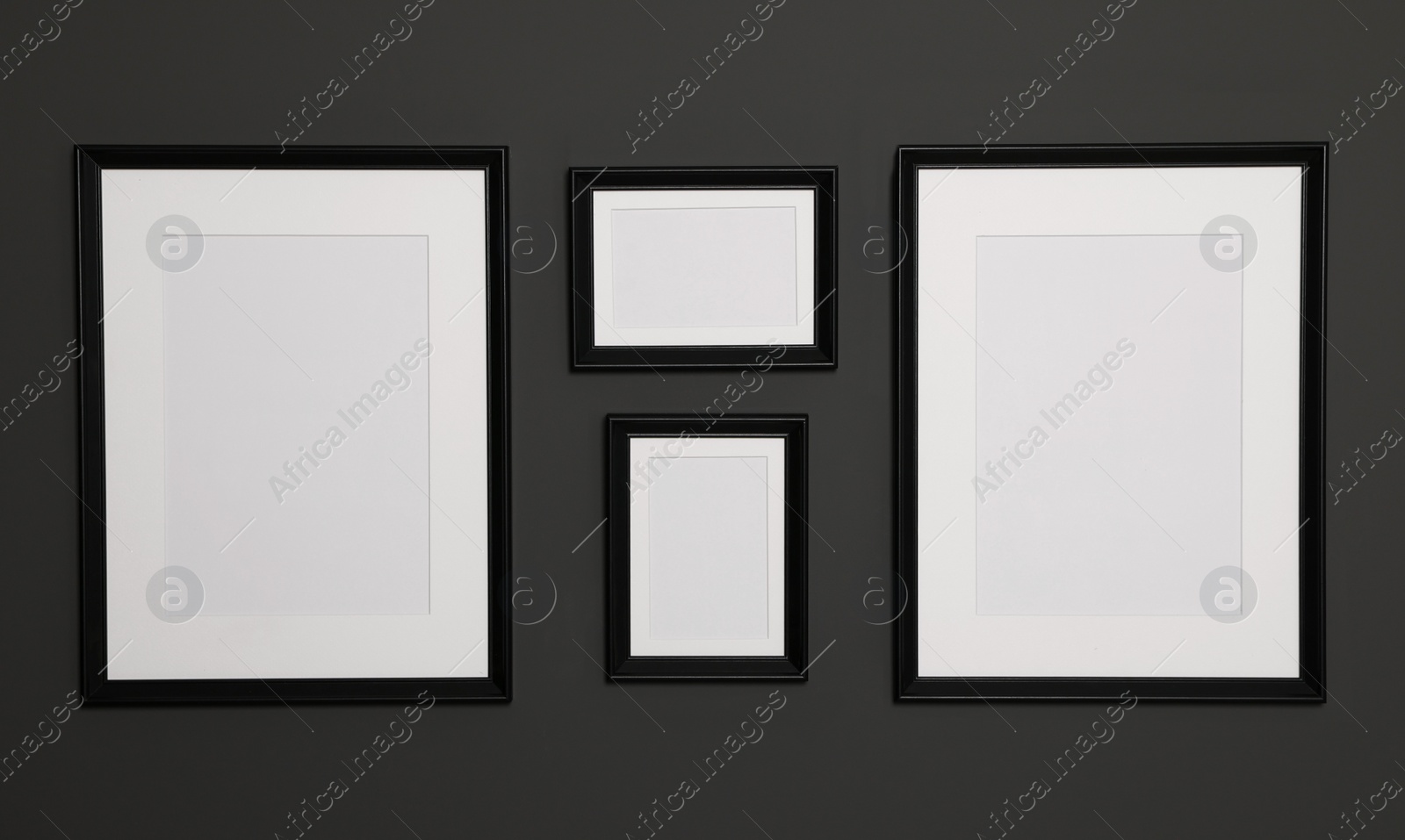 Photo of Empty frames on black wall. Mockup for design