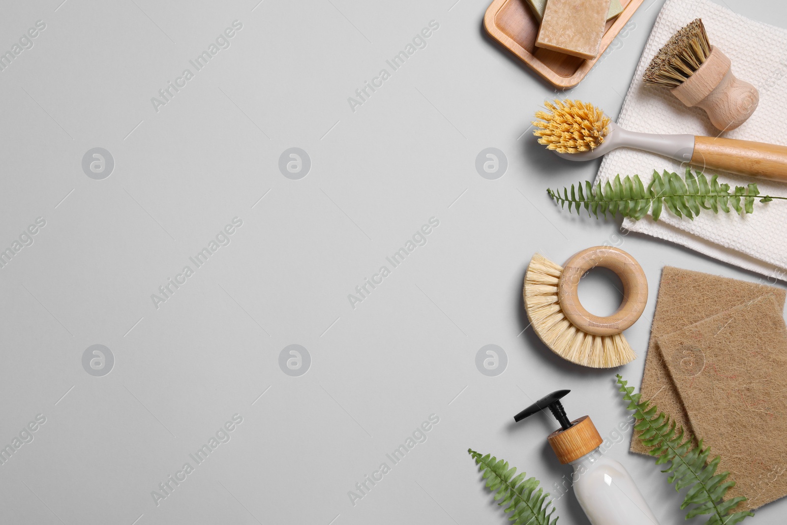 Photo of Different cleaning supplies on grey background, flat lay. Space for text