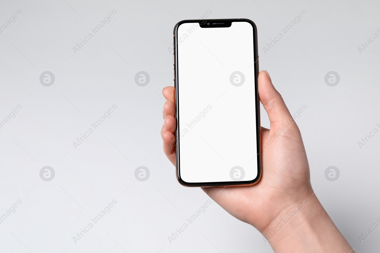 Photo of Woman holding smartphone with blank screen on white background, closeup. Mockup for design