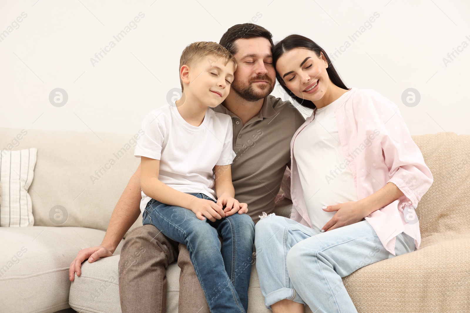 Photo of Happy pregnant woman spending time with her son and husband at home