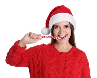Photo of Pretty woman in Santa hat and red sweater eating candy cane on white background