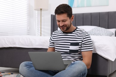 Photo of Happy man having video chat via laptop in bedroom