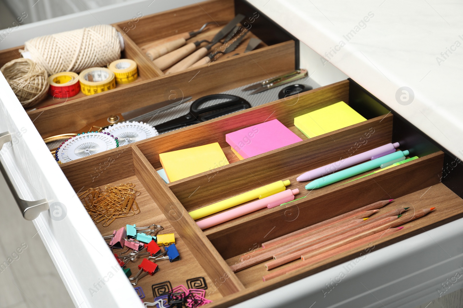 Photo of Different stationery in open desk drawer indoors, closeup