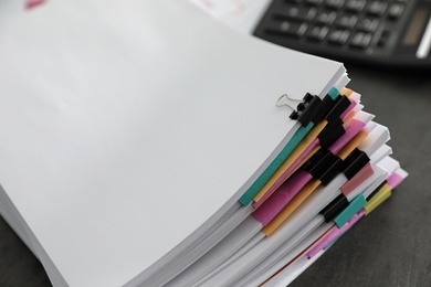 Photo of Stack of documents with paper clips on office table. Space for text