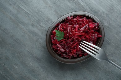 Photo of Tasty red cabbage sauerkraut with parsley on grey table, top view. Space for text