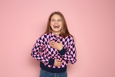 Photo of Portrait of young woman laughing on color background