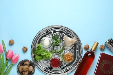 Photo of Flat lay composition with symbolic Passover (Pesach) items and meal on color background, space for text