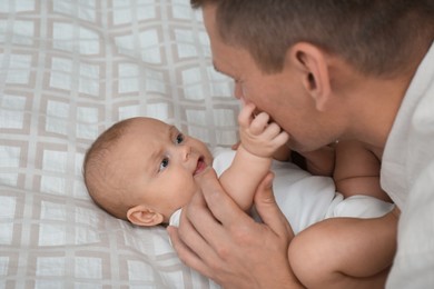 Father with his cute baby on bed, closeup