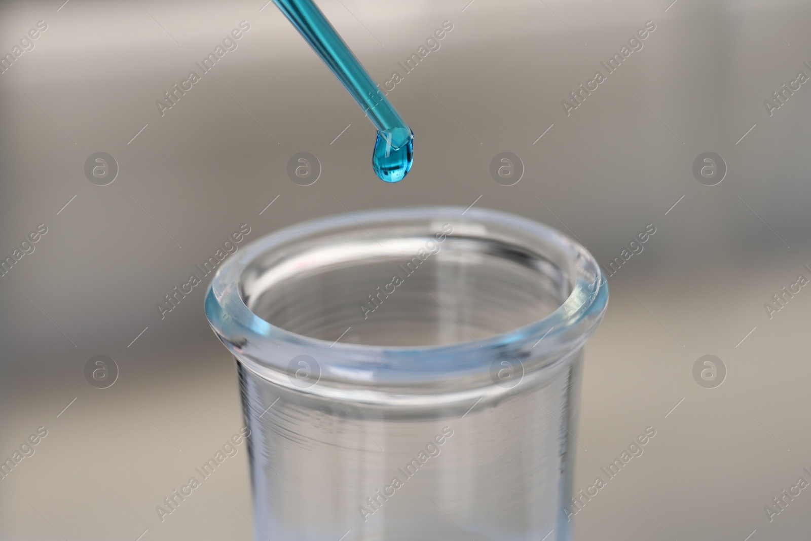 Photo of Laboratory analysis. Dripping blue liquid into flask on blurred background, closeup