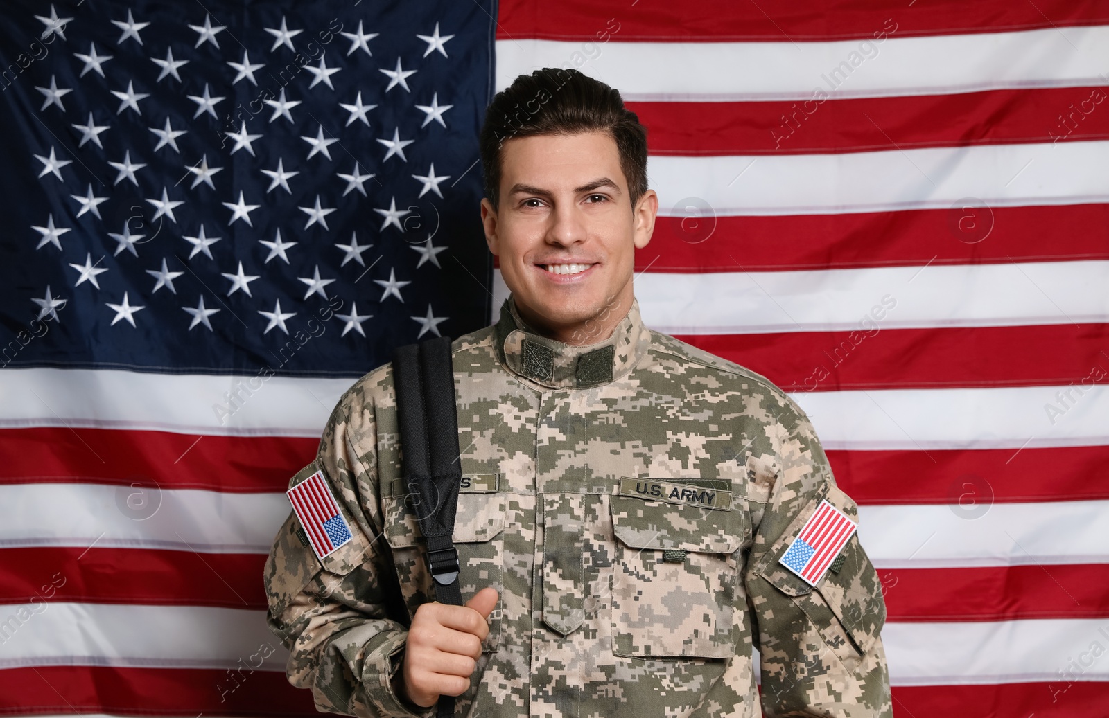 Photo of Cadet with backpack against American flag. Military education