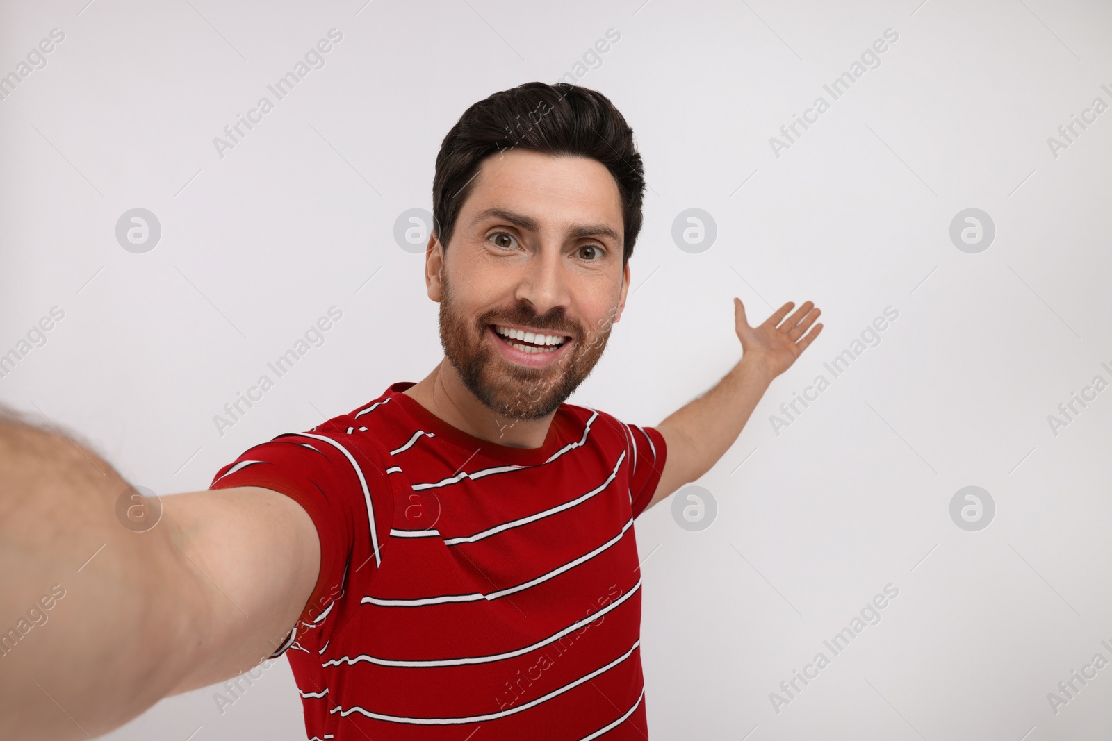 Photo of Smiling man taking selfie on white background