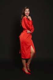 Photo of Happy woman in red dress on black background. Christmas party