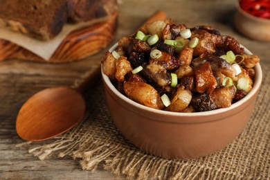 Photo of Tasty fried cracklings on wooden table, closeup. Cooked pork lard