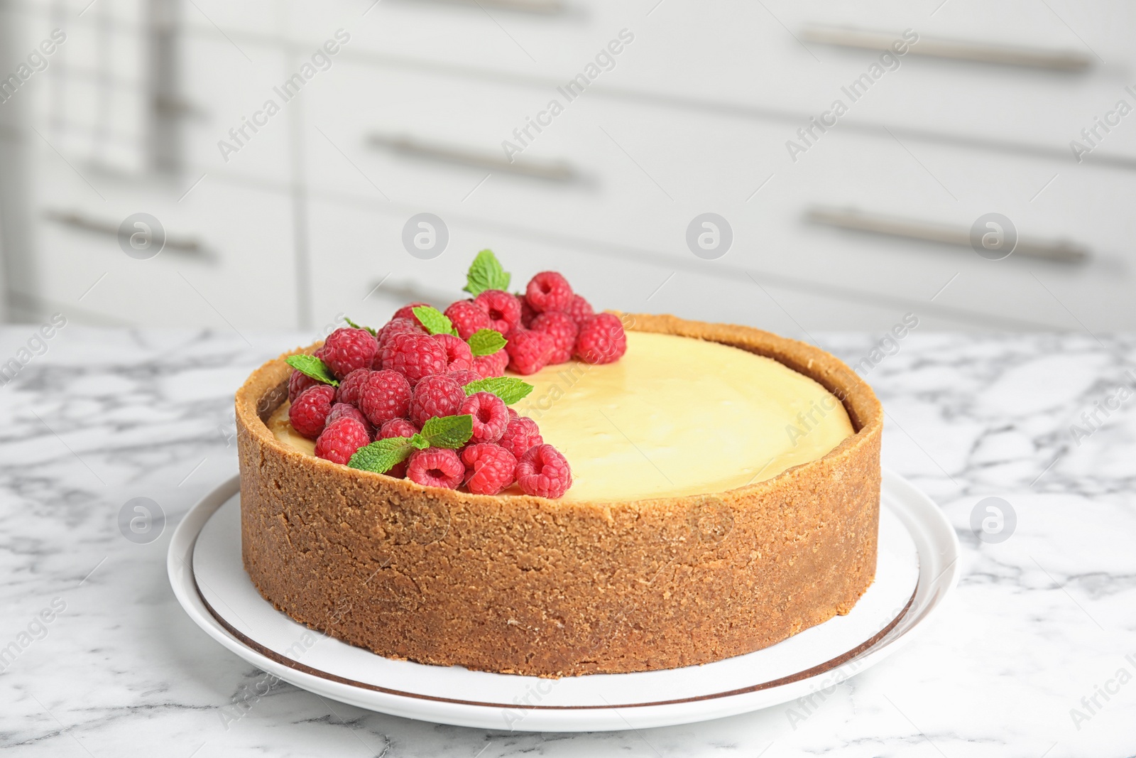 Photo of Dessert plate with delicious raspberry cake on marble table indoors