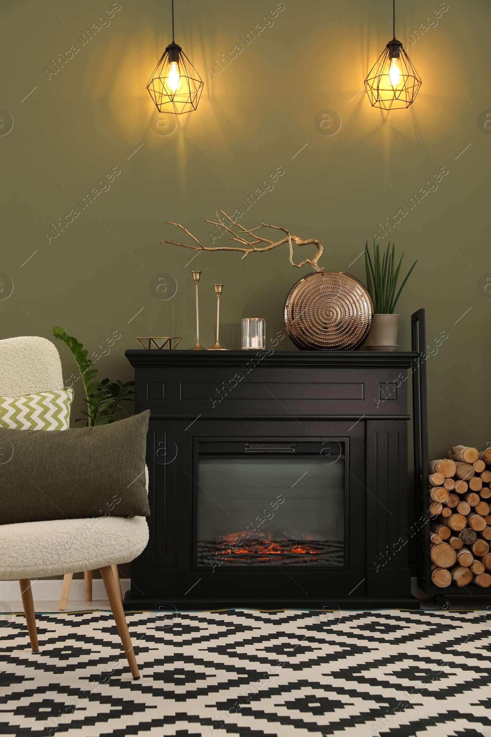 Photo of Beautiful fireplace, different decor and armchair in living room. Interior design