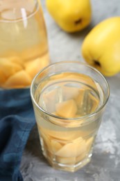 Delicious quince drink and fresh fruits on grey table, closeup