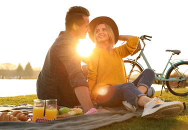 Happy young couple having picnic outdoors on sunny day