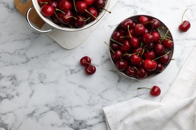 Photo of Fresh ripe cherries with water drops on white marble table, flat lay. Space for text
