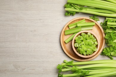 Photo of Many fresh cut celery stalks and bunches on wooden table, flat lay. Space for text