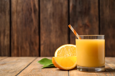 Glass of orange juice and fresh fruits on wooden table. Space for text