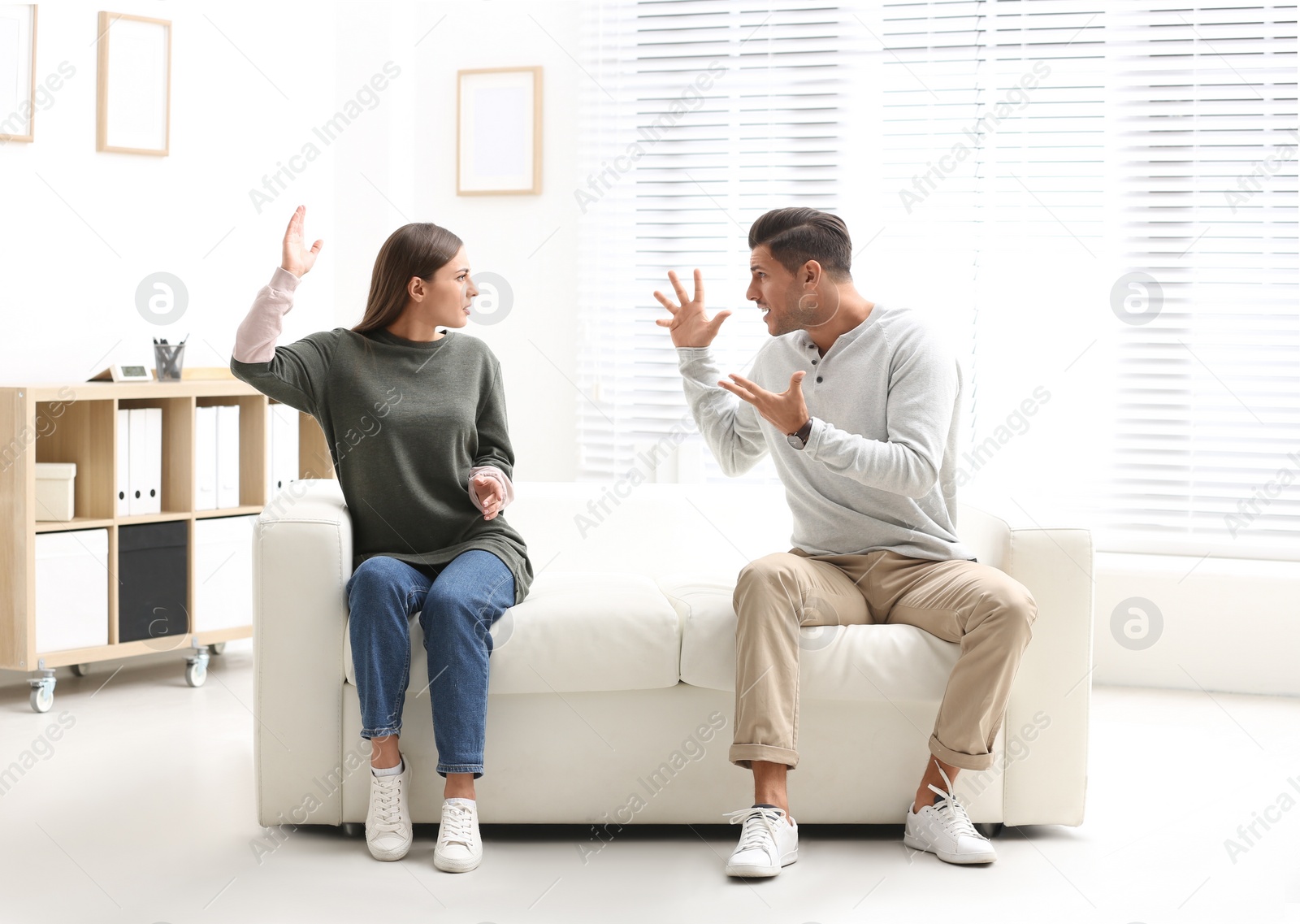 Photo of Emotional couple on sofa in psychologist's office