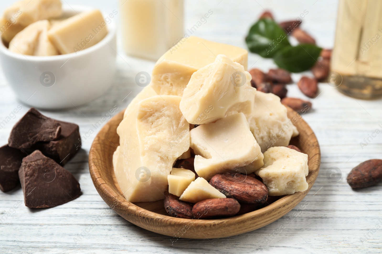 Photo of Composition with organic cocoa butter on white wooden table, closeup