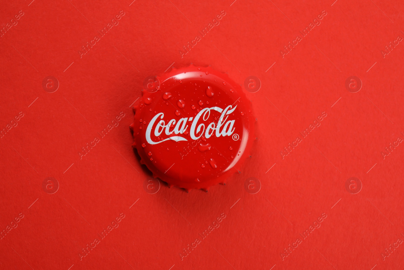 Photo of MYKOLAIV, UKRAINE - NOVEMBER 15, 2018: Coca Cola lid on color background, top view