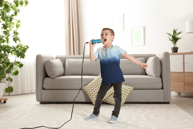Photo of Cute funny boy with microphone in living room