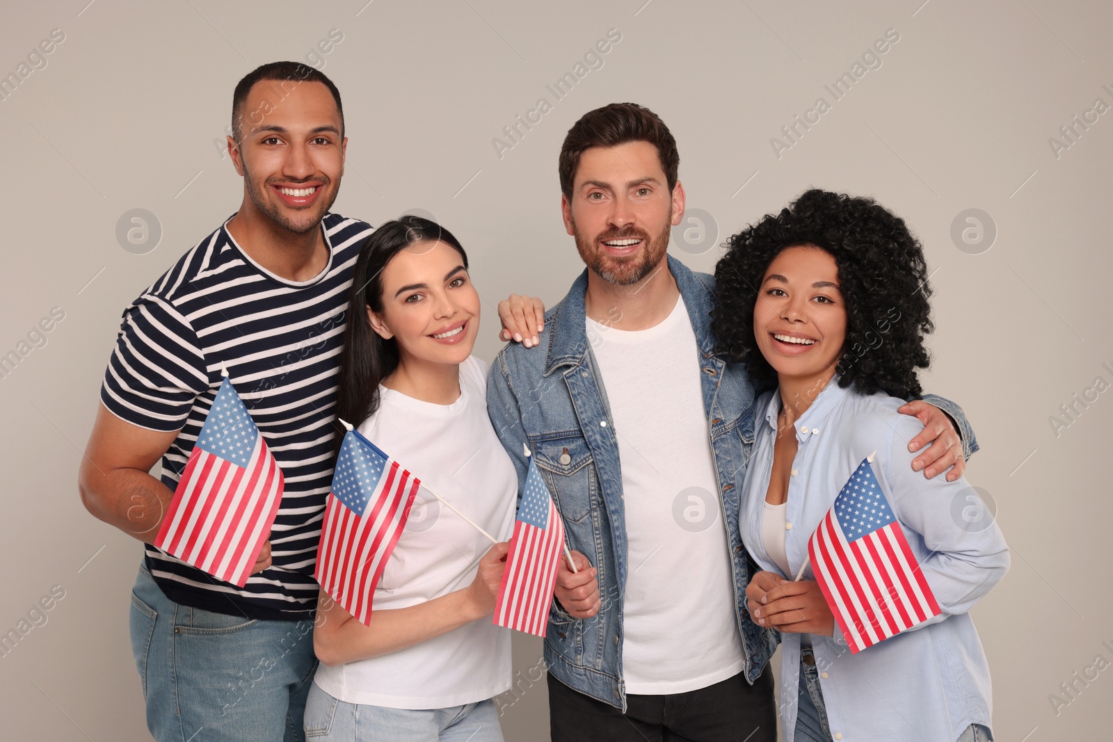 Photo of 4th of July - Independence Day of USA. Happy friends with American flags on grey background