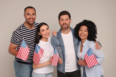 4th of July - Independence Day of USA. Happy friends with American flags on grey background