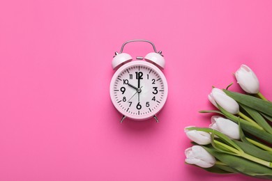Photo of Alarm clock and beautiful tulips on pink background, flat lay with space for text. Spring time
