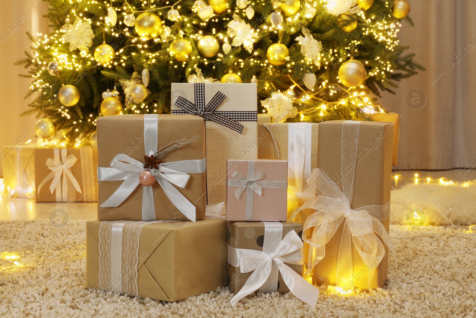 Photo of Many gift boxes near decorated Christmas tree at home