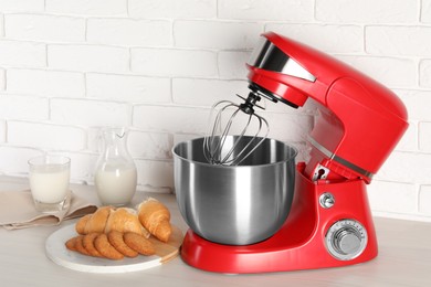 Photo of Modern red stand mixer, croissant and cookies on white wooden table, space for text