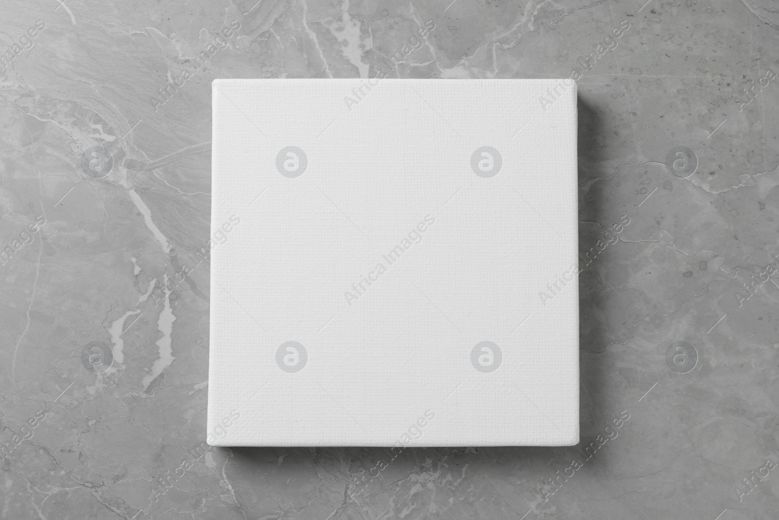 Photo of Blank canvas on grey marble table, top view. Space for text