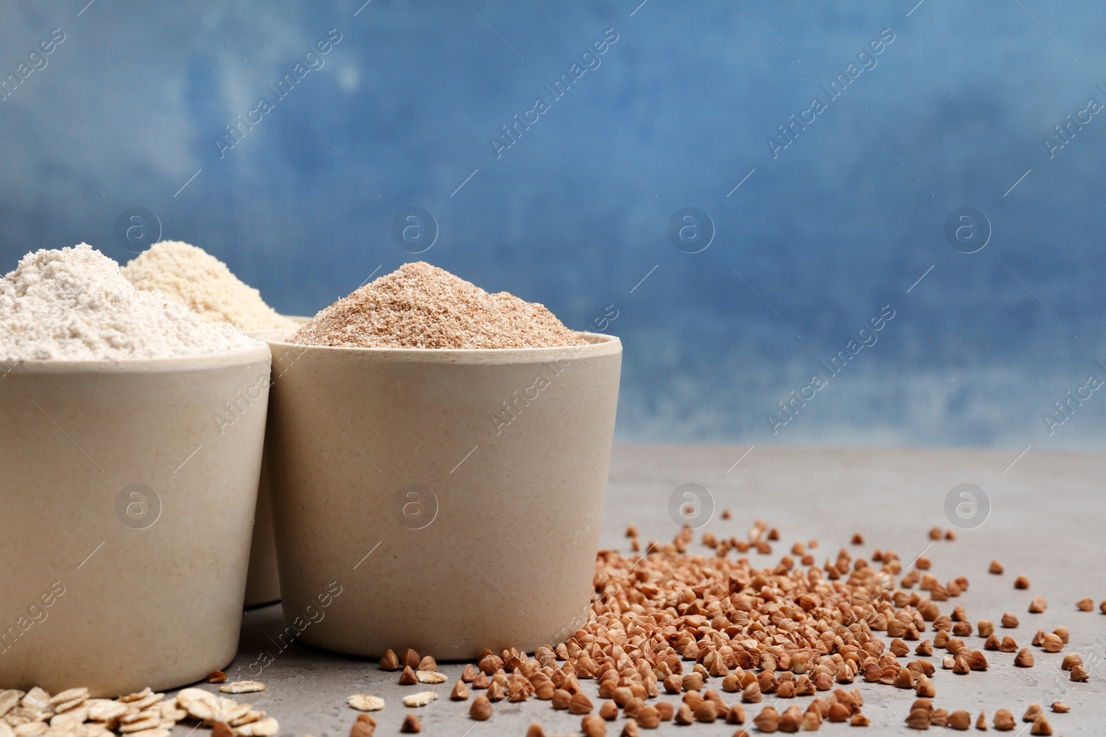 Photo of Composition with different types of flour on table against color background. Space for text