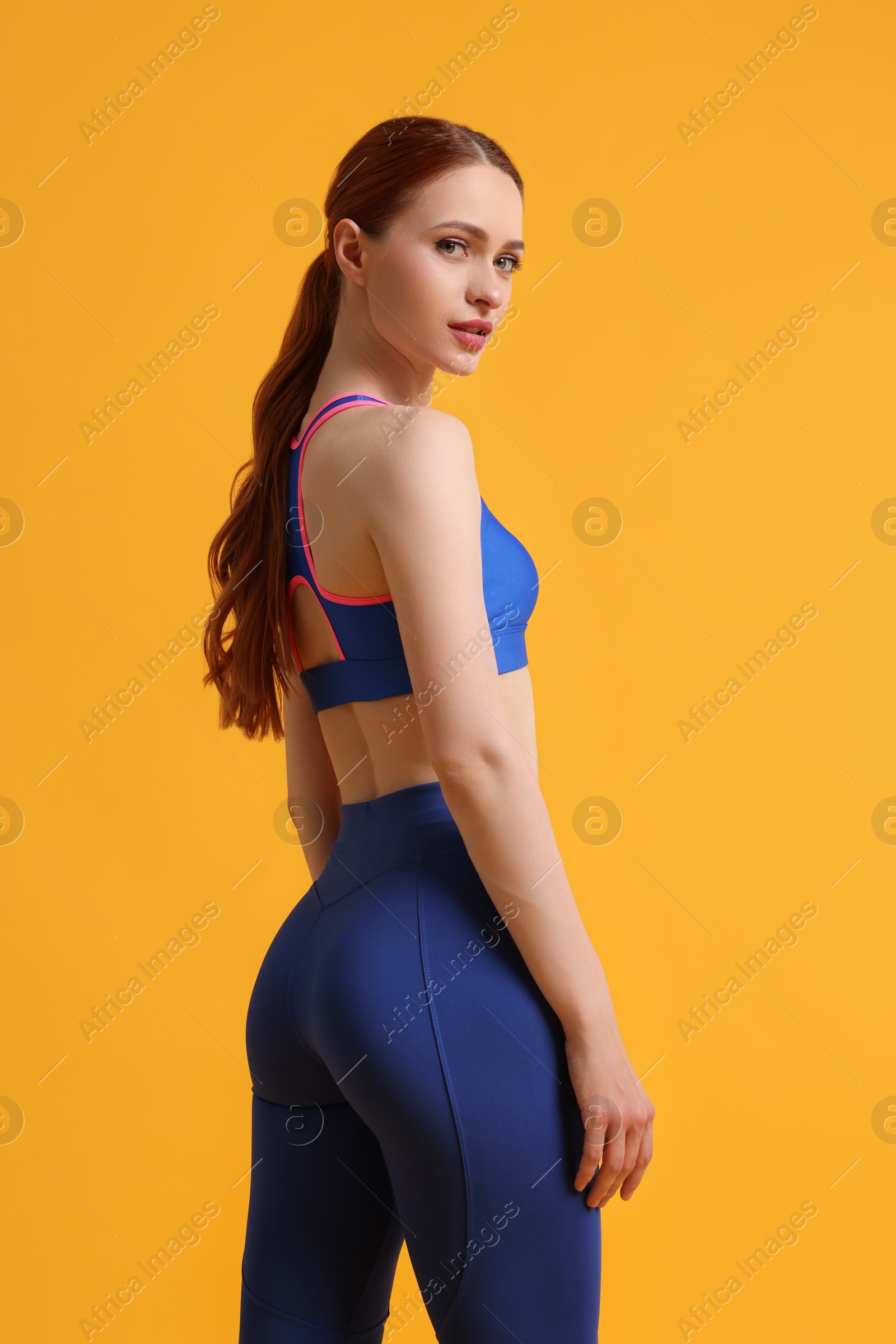 Photo of Young woman wearing sportswear on yellow background