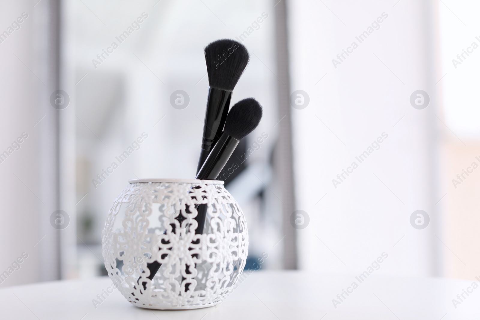 Photo of Holder with makeup brushes on table