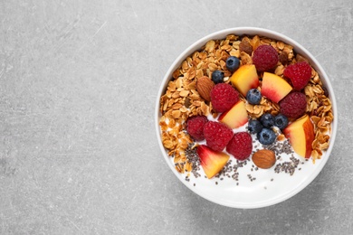 Healthy homemade granola with yogurt on grey table, top view. Space for text