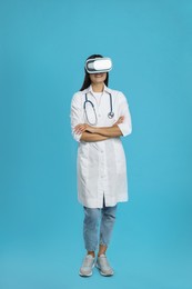 Photo of Female doctor using virtual reality headset on light blue background
