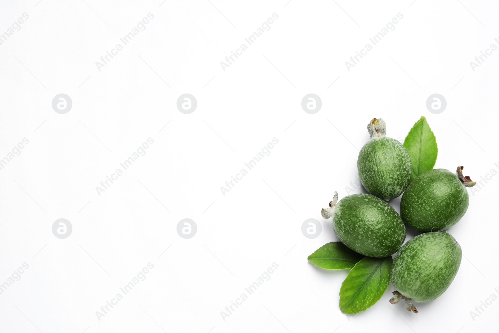 Photo of Pile of feijoas and leaves on white background, top view