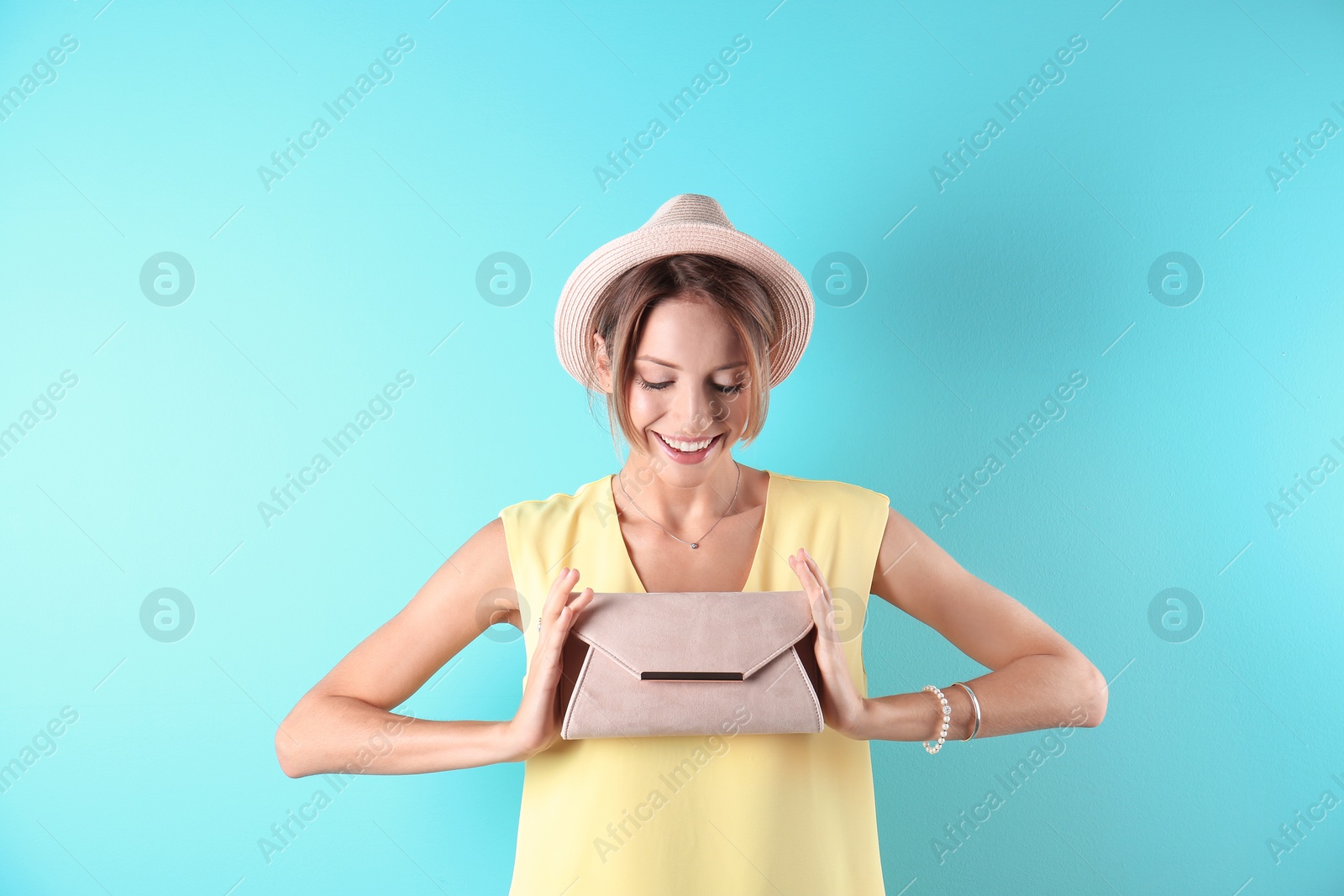 Photo of Portrait of young woman in stylish outfit with purse on color background