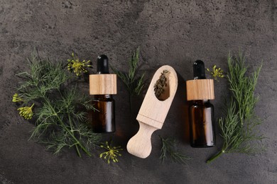 Bottles of essential oil and scoop with fresh dill on grey table, flat lay