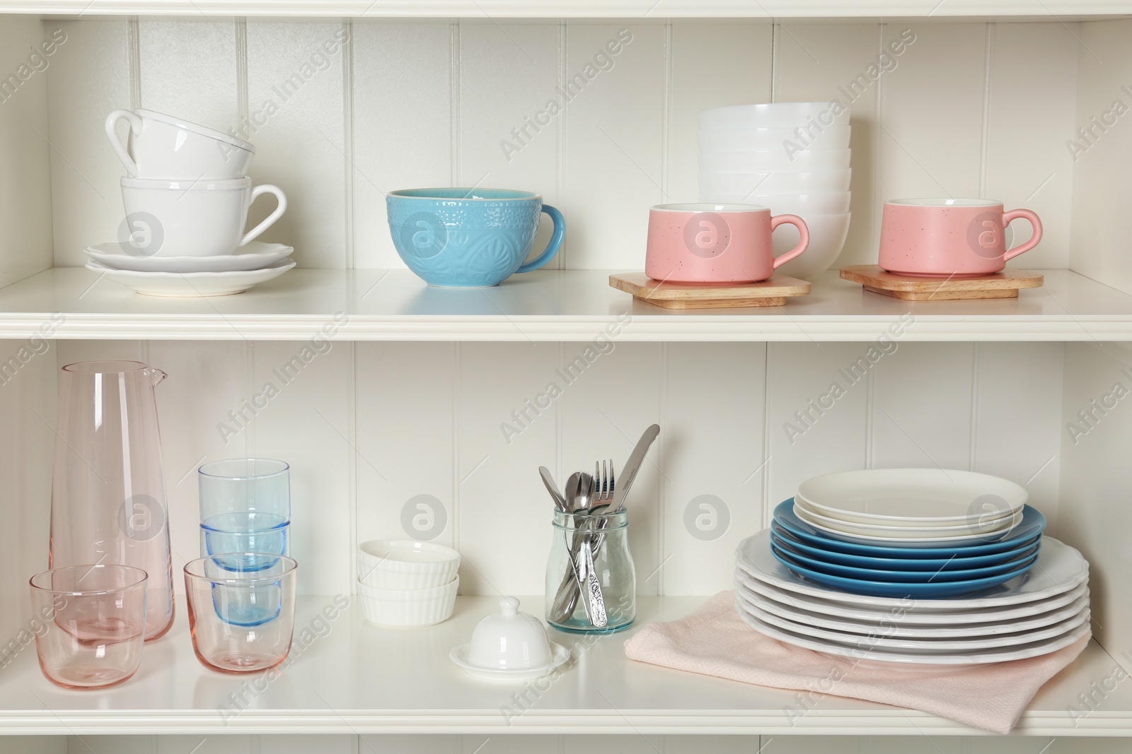 Photo of White shelving unit with set of dishware