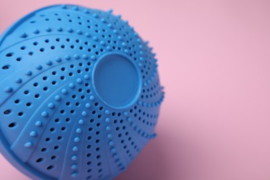Photo of Laundry dryer ball on pink background, closeup. Space for text