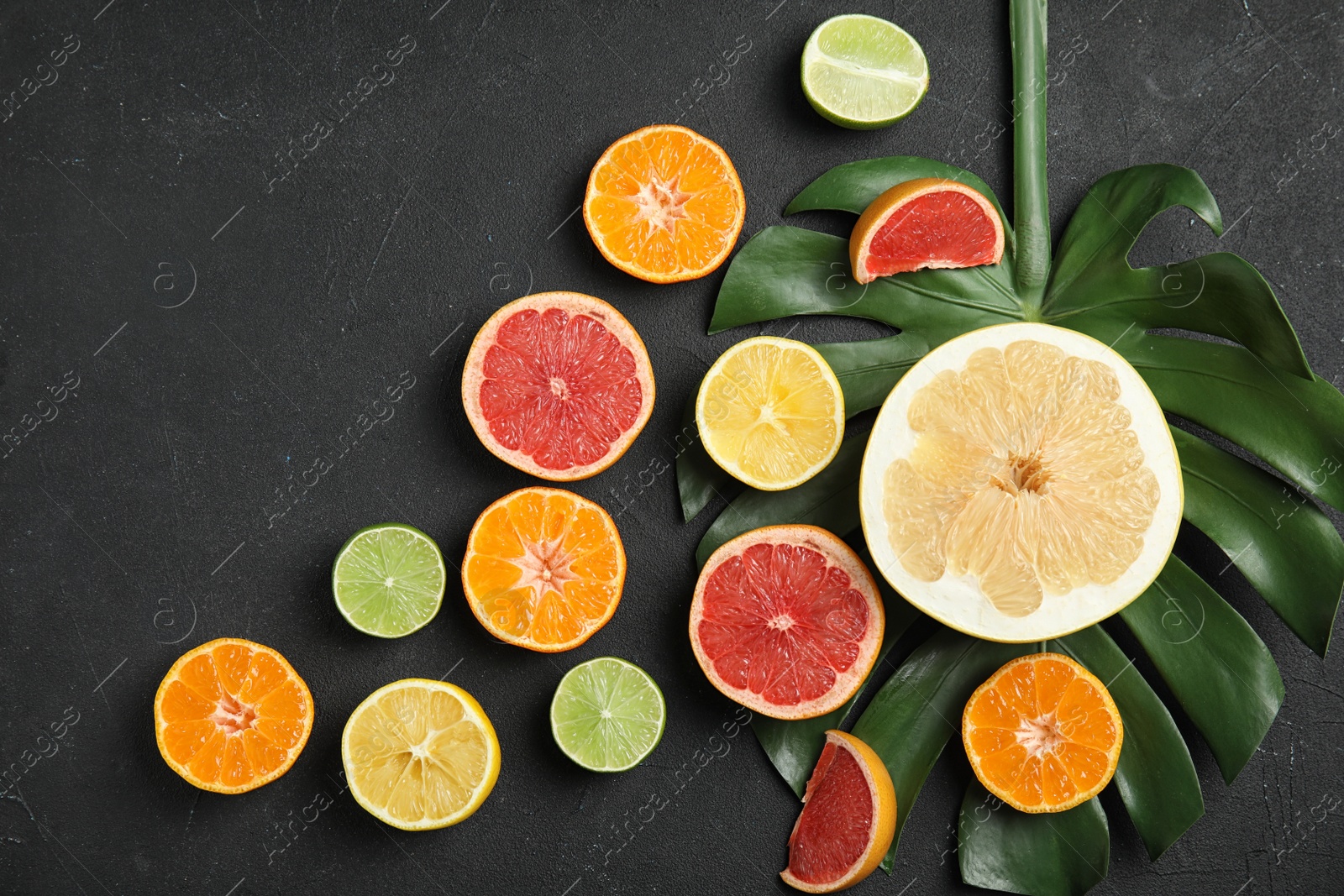 Photo of Different citrus fruits on black background, flat lay. Space for text