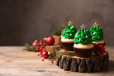 Christmas tree shaped cupcakes on wooden table. Space for text