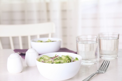 Photo of Delicious fresh cucumber onion salad served on table