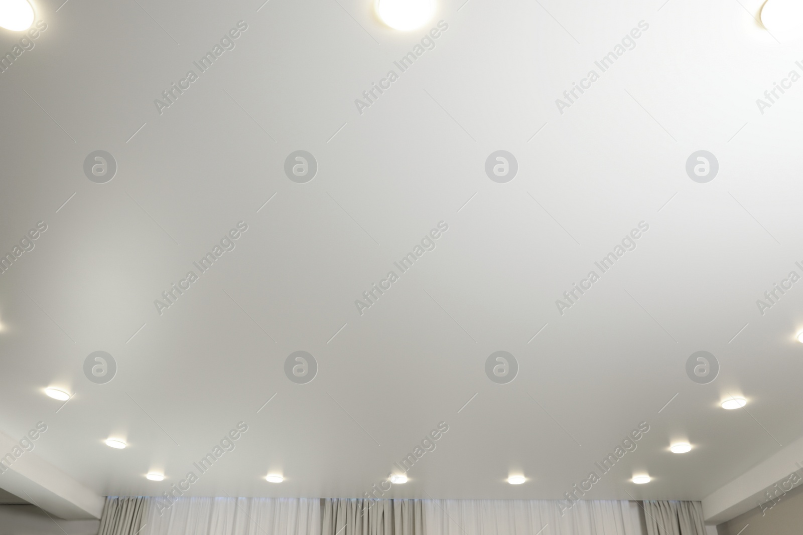 Photo of White ceiling with lamps indoors, below view