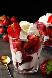 Photo of Delicious strawberries with whipped cream served on grey table